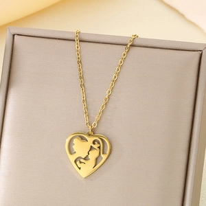 Detailed close-up of golden heart pendant with mother and child silhouette on jewelry box
