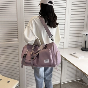 Purple large capacity travel bag with shoe compartment shown being worn by a model