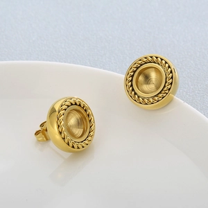 Close-up of gold round stud earrings with elegant twisted rope border on a white plate
