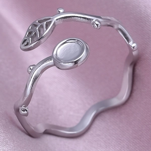 Macro shot of silver stainless steel leaf ring with adjustable open band on pink silk