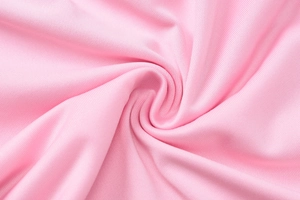 Detail of light pink knitted fabric showing tight texture and pleated elastic material