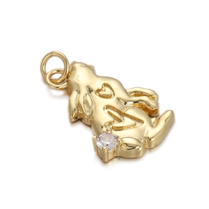 Detail of golden bunny pendant with heart carving and clear rhinestone on white background