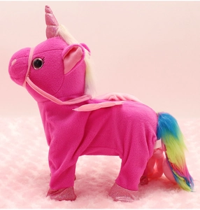 Detail of pink plush unicorn toy with shiny wings and rainbow tail on soft surface