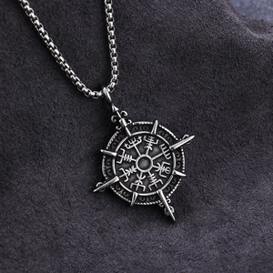 Vintage silver Viking Vegvisir compass pendant necklace on grey textured fabric background
