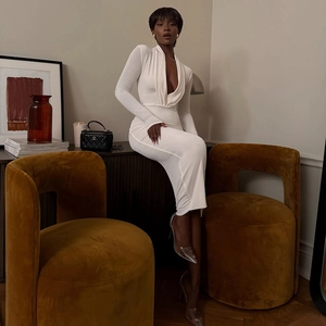 Détail d'une élégante robe blanche à manches longues avec décolleté en V et drapé
