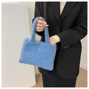 Blue fuzzy plush handbag held by a model showcasing soft texture and trendy compact design