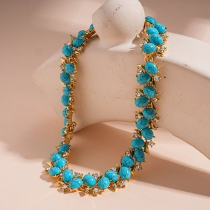 Detailed macro view of vintage resin zircon necklace with blue turquoise and gold metal