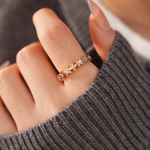 Macro view of 18k gold plated ring with colorful zircon floral accents on a model's finger
