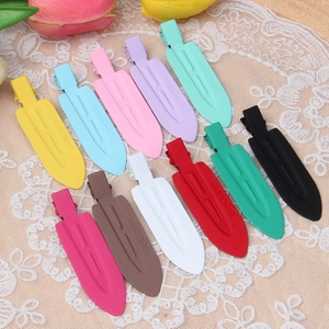 Colorful matte metal hair clips arranged neatly on lace fabric with tulip background