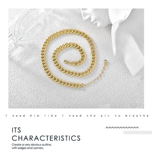 Detail view of 18K gold plated thick Cuban chain necklace with lobster clasp on white marble