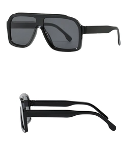 Detail of oversized black pilot sunglasses with dark grey UV protective lenses