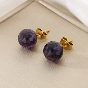 Detail of dark purple faceted crystal earrings with gold finish metal butterfly backings