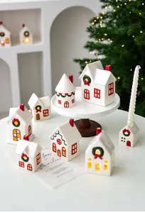 Macro view of white ceramic Christmas house village with festive glowing LED windows