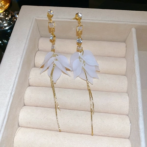 Vue détaillée des boucles d'oreilles fleurs en acrylique avec zircons et pampilles