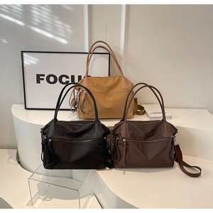 Multiple nylon tote bags in khaki, black and dark brown with leather handles displayed
