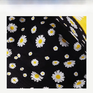 Macro detail of the high-density daisy embroidery on black fabric for fisherman hat
