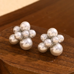 Macro detail of high-quality pearl cluster earrings with multiple white pearls and silver base