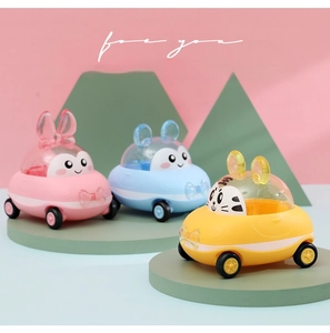 Close-up of cute plastic animal toy cars in pink, blue and yellow on a green round tray