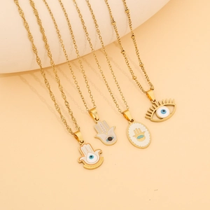 Golden Hamsa Hand and Evil Eye necklace set with enamel details on warm background