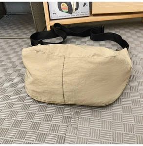 Detail view of khaki nylon dumpling bag with adjustable black shoulder strap and large capacity