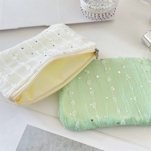 Detail of sequined chiffon coin purses in cream and mint green with metal zippers