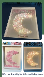 Detail of moon-shaped crystal wall art with pink crushed diamonds and glowing LED effect