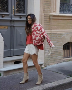 Gros plan d'une veste matelassée pour femme avec motif géométrique rouge et crème