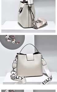 Detail of white lychee leather bucket bag with artistic patterned wide shoulder strap