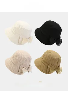 Detail showing foldable bow sun hats in white, black, beige, and khaki color options