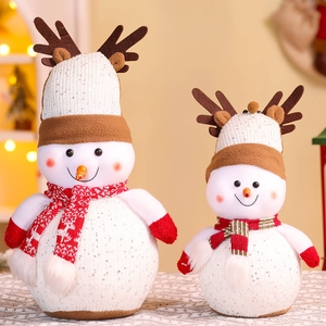 Close-up of plush Christmas snowman ornaments with red striped scarves and reindeer antlers
