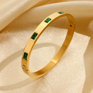 Polished 18K gold stainless steel bangle featuring five rectangular emerald green zircons