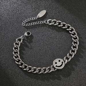 Detail of silver titanium steel chain bracelet with smiley face and oval metal plate