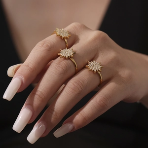 Three gold sunburst rings with 5A zircon crystals on model fingers in a premium set