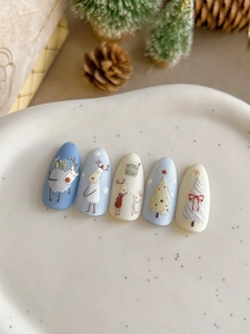 Detailed view of Christmas nail art stickers with reindeer and tree patterns on a tray