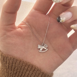 Detail of silver rocking horse pendant with white shell and zircon on a fine chain