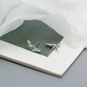 Macro view of silver leaf earring with olive branch design and sparkling zircon stones