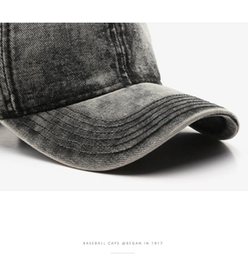 Detailed close-up of vintage washed grey denim baseball cap with stitched brim and texture