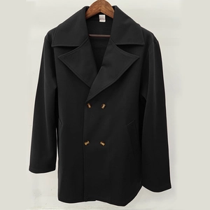 Detailed view of double-breasted black coat with brown amber-patterned buttons