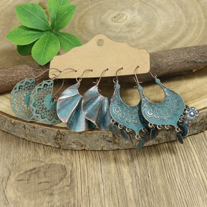 Detail of three vintage bohemian earrings in bronze finish with turquoise patina accents