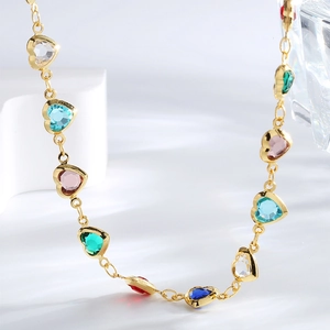 Golden necklace with multi-colored heart-shaped zircon pendants on white wavy stand