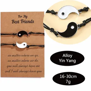 Macro detail of yin yang friendship bracelets with adjustable cords on a kraft card