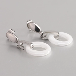 Minimalist silver stainless steel earrings featuring round white ceramic ring pendants