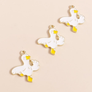 Detail of funny white duck alloy charms with golden outlines and yellow accents