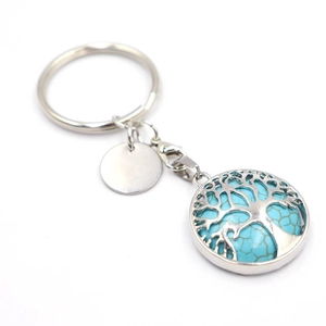 Macro detail of Tree of Life keychain with blue turquoise and lobster clasp on white background