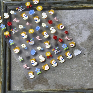 Detailed macro of 3D embossed nail stickers featuring cute ducks and summer floral patterns