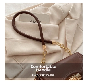 Close-up of a dark brown leather handbag with gold chain strap and curved handle detail