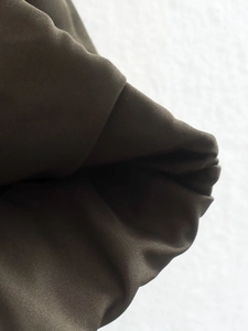 Gros plan sur la texture du tissu sergé olive foncé pour veste ample pour femme