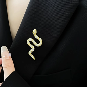 Close-up of gold-plated snake brooch with sparkling zircons on a black blazer lapel