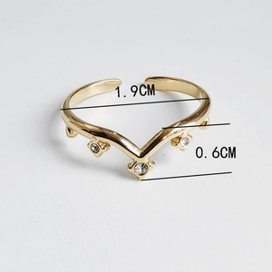 Macro shot of 18K gold plated V-shape titanium steel ring with three clear zircons