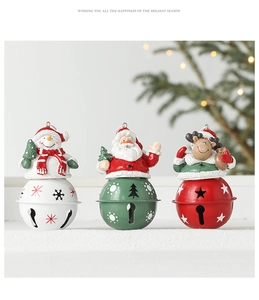 Detailed view of Christmas resin dolls and metal bells with star cutouts for tree decor